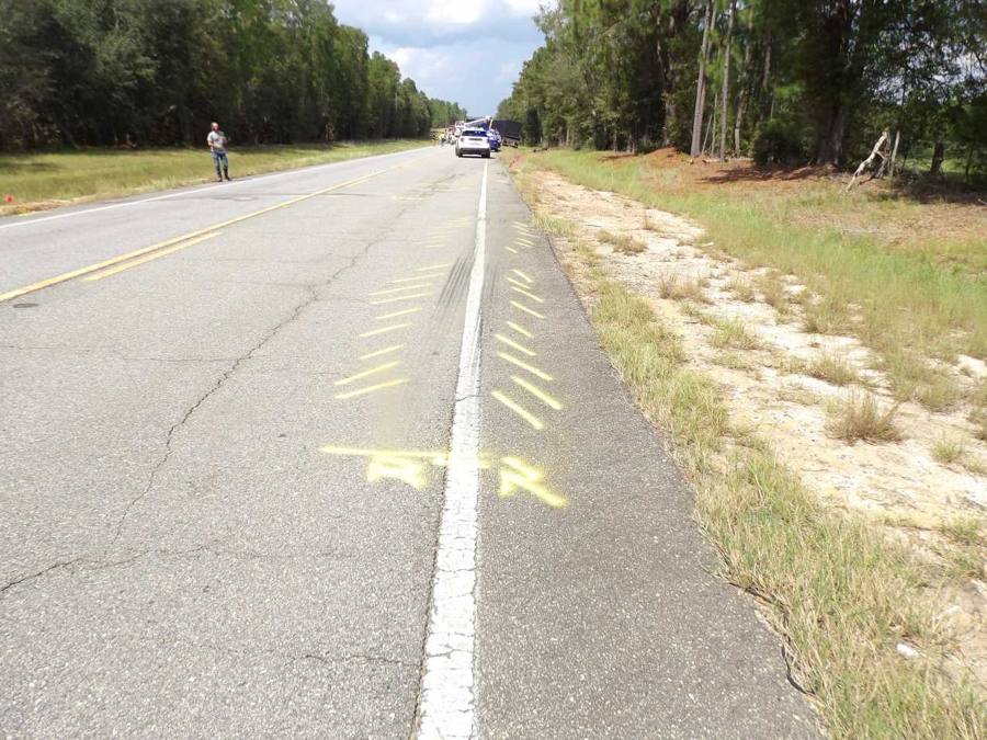 Skid marks marked by investigators on a two-lane highway